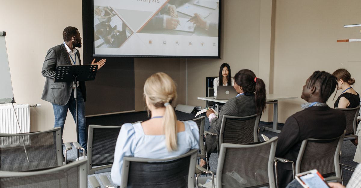 Profesional impartiendo una formación ante un equipo en una sala de reuniones moderna