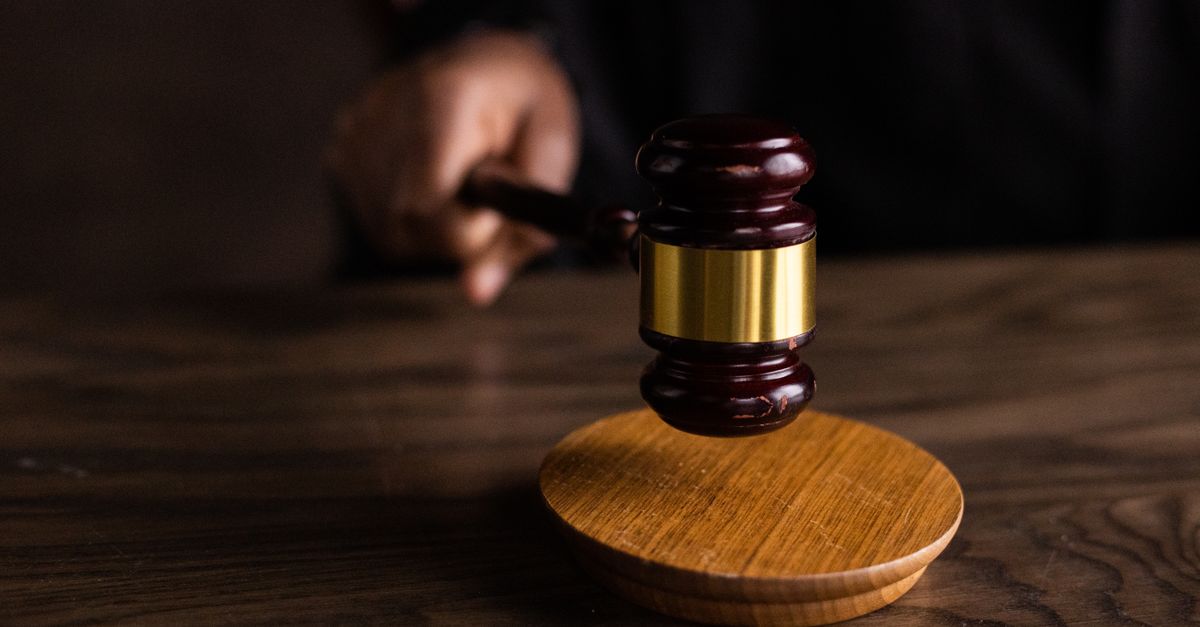Mazo de juez sobre una mesa de madera, símbolo de la sanción y la autoridad legal